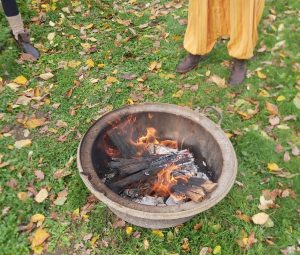 Feu de camp entouré de bougies et de fleurs pendant un cercle à Le Shamballa.